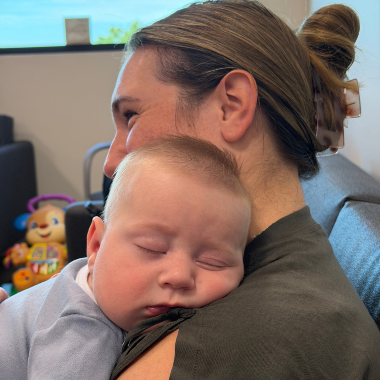 New mother holding her baby, illustrating the need for postpartum mental health care after birth